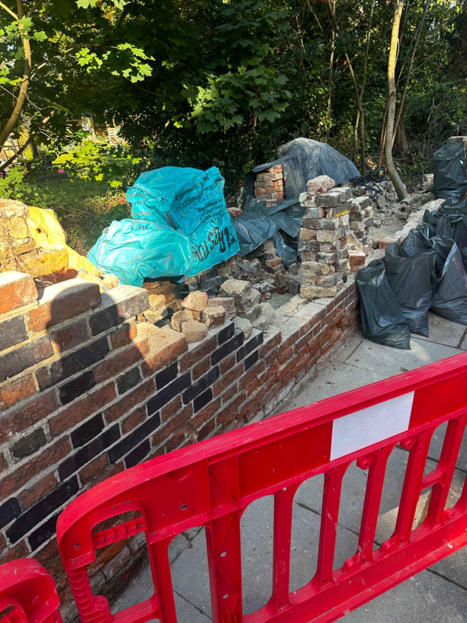 Brick wall demolition in progress on Westcombe Park Road SE3 Greenwich — old brickwork removed with safety barriers in place